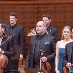 Orchestra members performing on stage